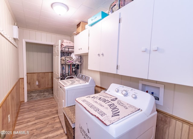 2405 S Chataignier Rd, Ville Platte, LA 70586 - laundry room with cabinet space, independent washer and dryer, light wood-style flooring, and wood walls