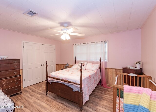 2405 S Chataignier Rd, Ville Platte, LA 70586 - bedroom featuring wainscoting, light wood finished floors, wooden walls, and a ceiling fan