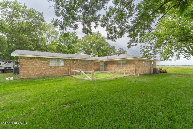 2405 S Chataignier Rd, Ville Platte, LA 70586 - rear view of property featuring central AC, a lawn, and brick siding