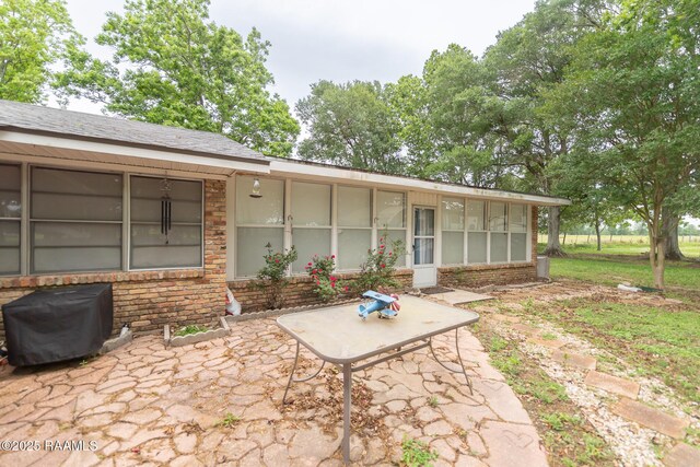 2405 S Chataignier Rd, Ville Platte, LA 70586 - back of house featuring a patio, brick siding, and a sunroom