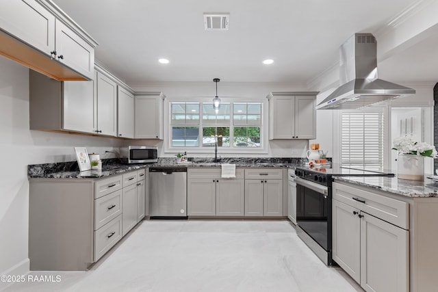 kitchen featuring appliances with stainless steel finishes, island range hood, dark stone countertops, ornamental molding, and a sink