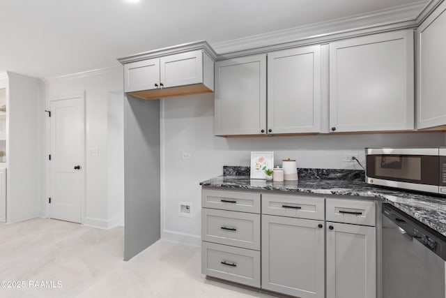 kitchen with stainless steel appliances, gray cabinets, dark stone countertops, crown molding, and baseboards