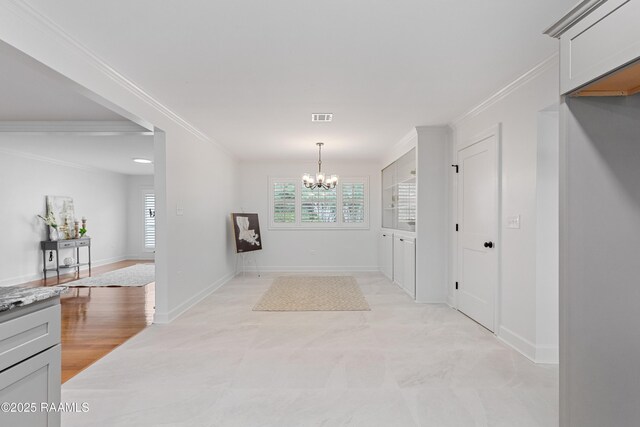 hall featuring ornamental molding, a chandelier, plenty of natural light, and baseboards