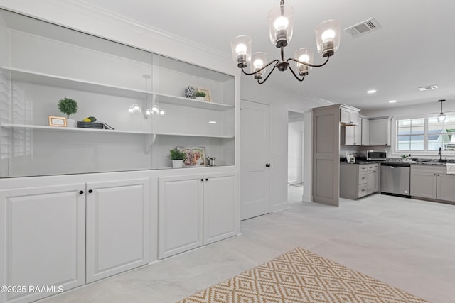 kitchen with appliances with stainless steel finishes, a chandelier, a sink, crown molding, and gray cabinetry