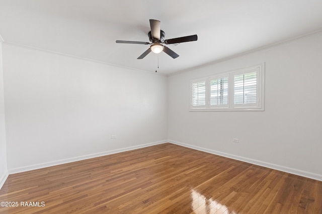 empty room featuring ornamental molding, baseboards, light wood-style floors, and a ceiling fan