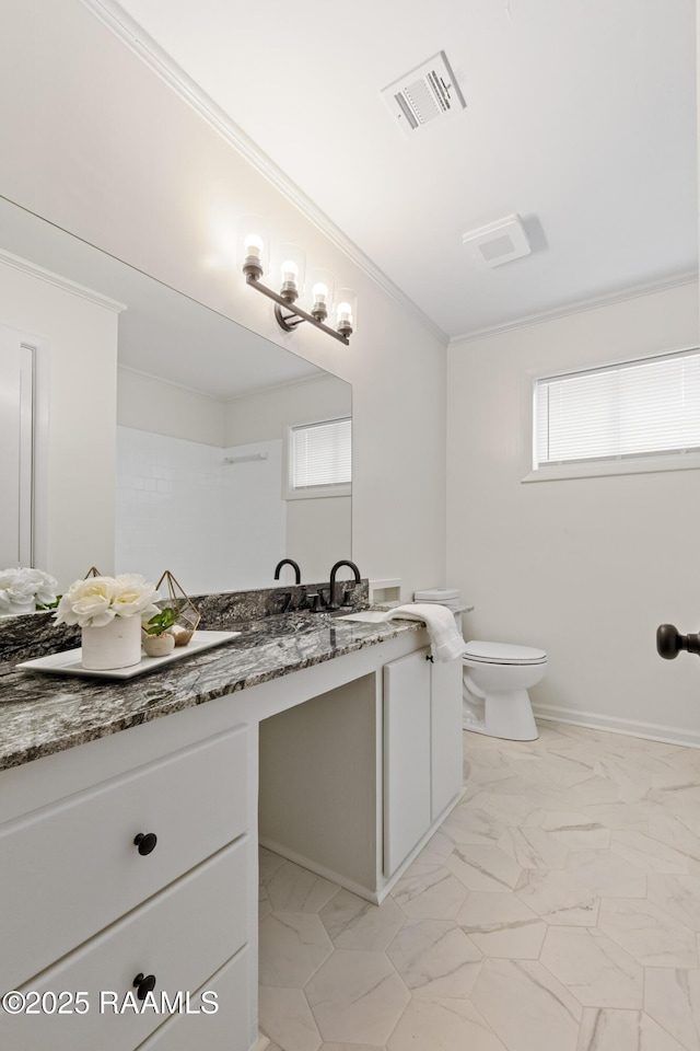 bathroom with vanity, crown molding, toilet, marble look tile flooring, and baseboards