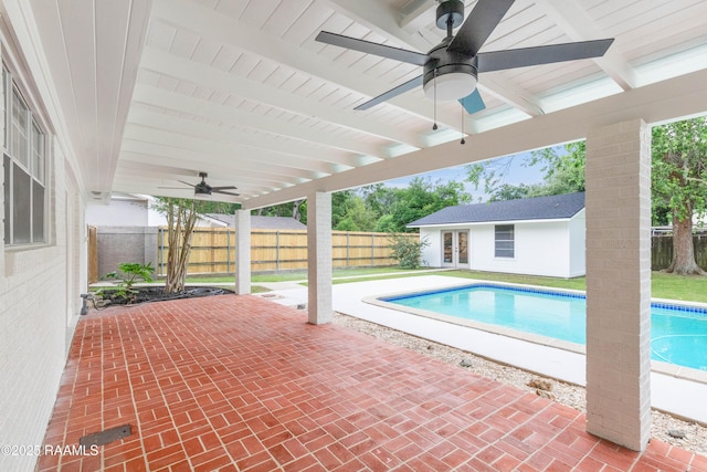 view of swimming pool with french doors, ceiling fan, a fenced backyard, a patio area, and an outdoor structure