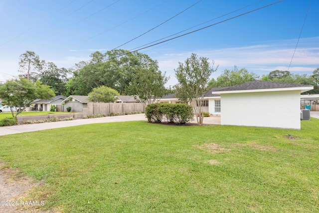 view of yard with cooling unit and concrete driveway