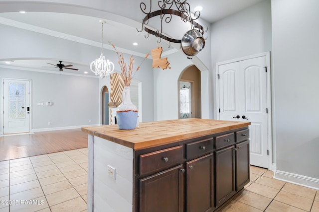 123 Laurel Grove Blvd, Youngsville, LA 70592 - kitchen with arched walkways, crown molding, light tile patterned flooring, ceiling fan, and a chandelier