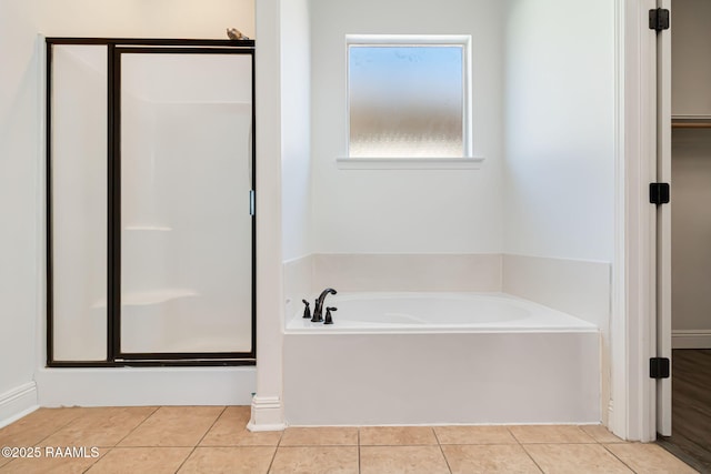 123 Laurel Grove Blvd, Youngsville, LA 70592 - bathroom with a bath, a stall shower, tile patterned floors, and a walk in closet