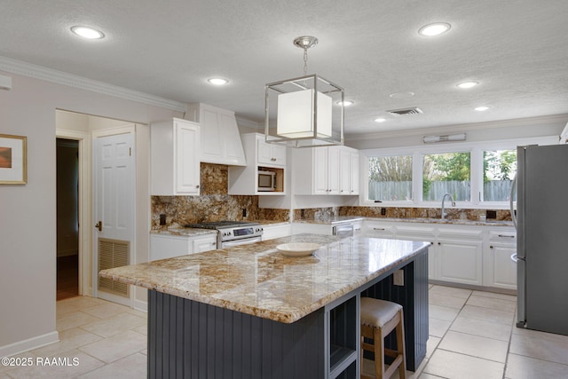 207 Beverly Dr, Lafayette, LA 70503 - kitchen with stainless steel appliances, white cabinets, ornamental molding, light stone countertops, and recessed lighting