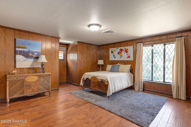 207 Beverly Dr, Lafayette, LA 70503 - bedroom with wood walls, wood finished floors, a textured ceiling, and baseboards