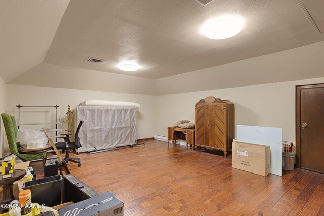207 Beverly Dr, Lafayette, LA 70503 - office featuring wood finished floors, vaulted ceiling, and a textured ceiling
