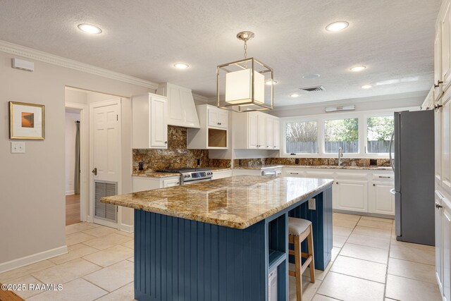 207 Beverly Dr, Lafayette, LA 70503 - kitchen with stainless steel appliances, ornamental molding, a breakfast bar, light stone countertops, and white cabinets
