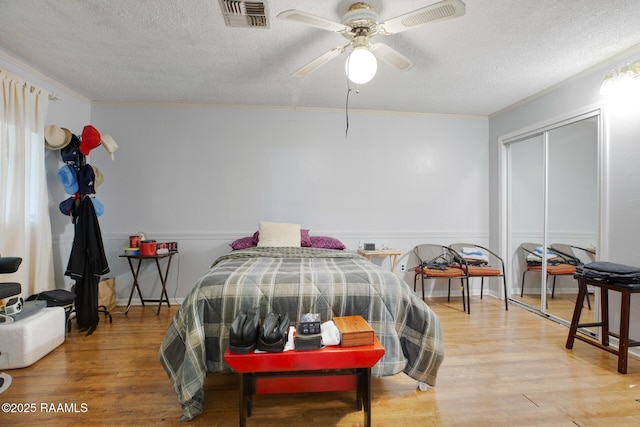 114 Marina Loop, Scott, LA 70583 - bedroom with crown molding, light wood finished floors, a textured ceiling, ceiling fan, and a closet