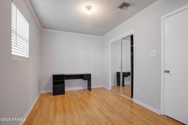 114 Marina Loop, Scott, LA 70583 - unfurnished bedroom with a textured ceiling, light wood finished floors, ornamental molding, a closet, and baseboards