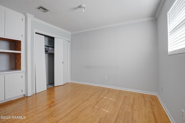 114 Marina Loop, Scott, LA 70583 - unfurnished bedroom with light wood-type flooring, crown molding, a textured ceiling, a closet, and baseboards