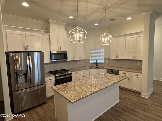 kitchen with appliances with stainless steel finishes, a chandelier, white cabinetry, a sink, and recessed lighting