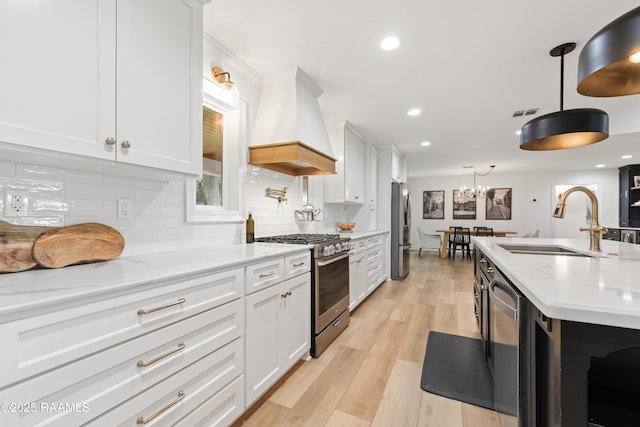 436 Brentwood Blvd, Lafayette, LA 70503 - kitchen with range hood, stainless steel appliances, a sink, white cabinets, and recessed lighting