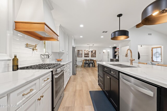 436 Brentwood Blvd, Lafayette, LA 70503 - kitchen with stainless steel appliances, custom range hood, a sink, white cabinets, and backsplash