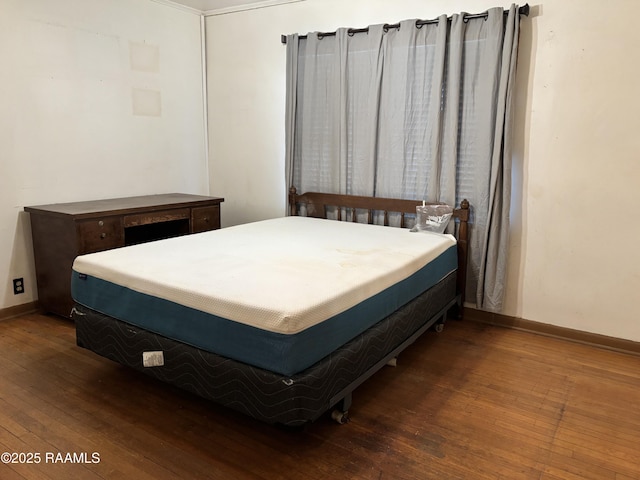 bedroom featuring wood-type flooring and baseboards