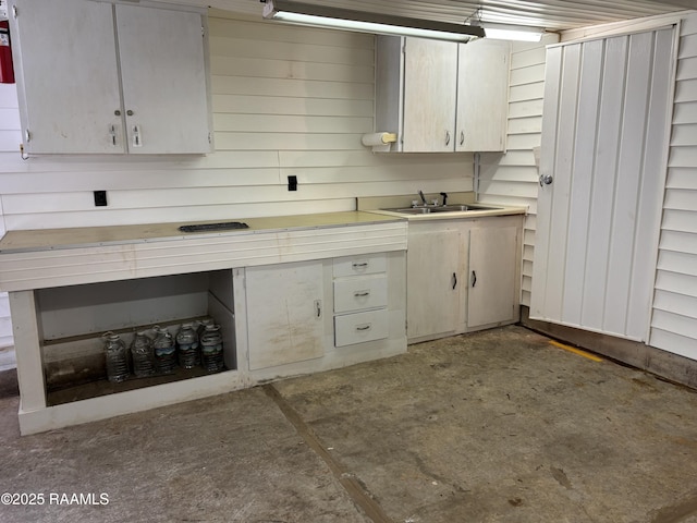 kitchen featuring a sink, light countertops, and unfinished concrete floors