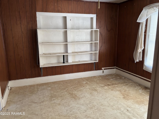 unfurnished room featuring tile patterned floors and wood walls