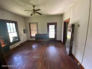 736 N Court St, Opelousas, LA 70570 - unfurnished living room featuring wood finished floors, a ceiling fan, and baseboards
