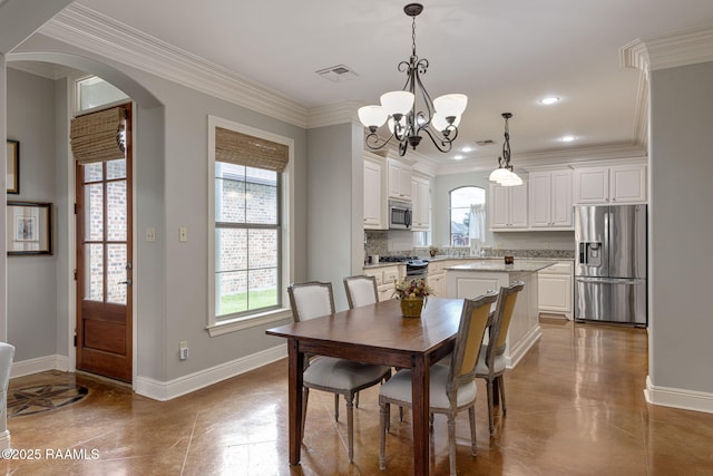 109 Barataria Bay, Lafayette, LA 70508 - dining room featuring arched walkways, a chandelier, baseboards, healthy amount of natural light, and crown molding