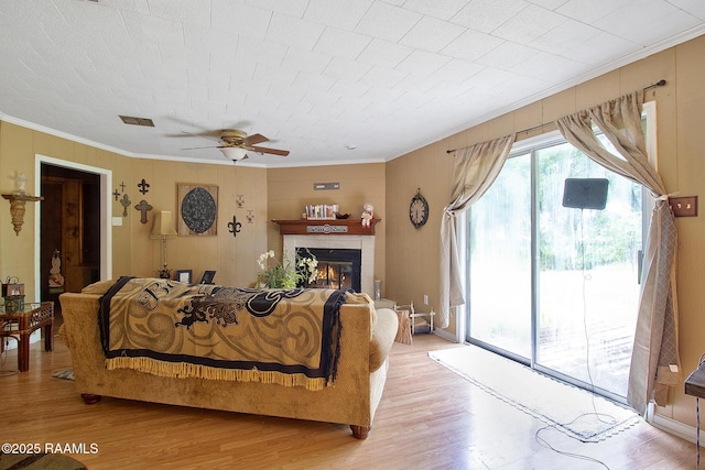 700 Guidry Rd, Lafayette, LA 70503 - living room featuring crown molding, light wood-style floors, a ceiling fan, and a glass covered fireplace