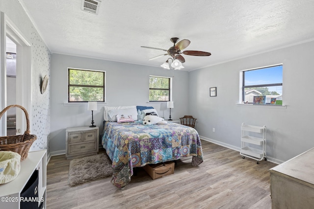 906 Fontenot St, Iowa, LA 70647 - bedroom with light wood finished floors, a textured ceiling, baseboards, and ceiling fan