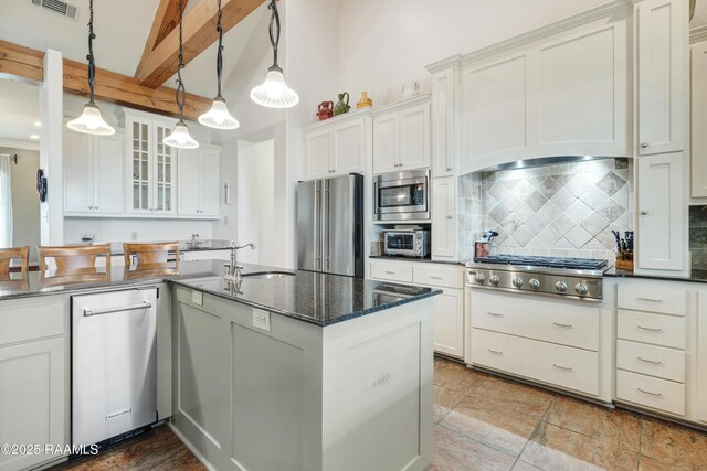 2311 Vida Shaw Rd, New Iberia, LA 70563 - kitchen featuring stainless steel appliances, decorative backsplash, a sink, glass insert cabinets, and dark stone countertops