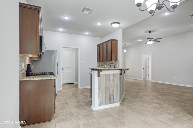 223 Moss Bluff Dr, Lafayette, LA 70507 - kitchen with decorative backsplash, stainless steel microwave, a ceiling fan, a chandelier, and recessed lighting
