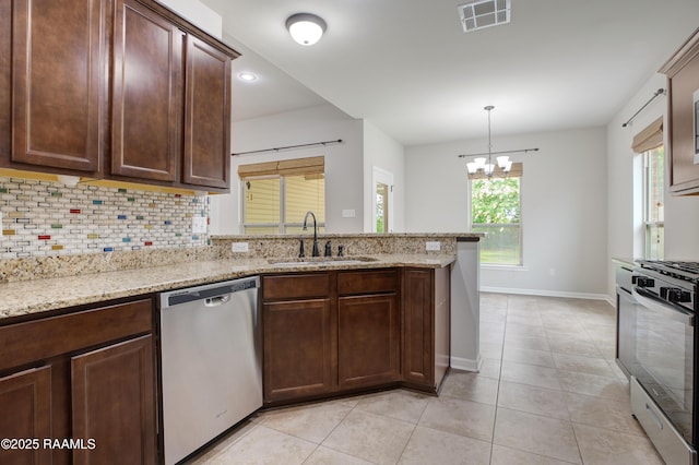 223 Moss Bluff Dr, Lafayette, LA 70507 - kitchen with appliances with stainless steel finishes, a sink, baseboards, backsplash, and a peninsula