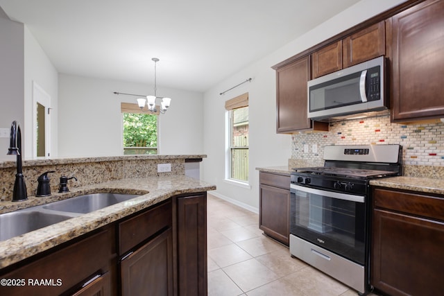 223 Moss Bluff Dr, Lafayette, LA 70507 - kitchen featuring appliances with stainless steel finishes, a sink, backsplash, a chandelier, and light tile patterned flooring
