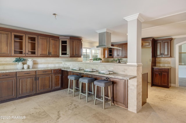 807 Cambridge Dr Res, Unit Res, Lafayette, LA 70503 - kitchen featuring backsplash, crown molding, a kitchen bar, glass insert cabinets, and light stone counters