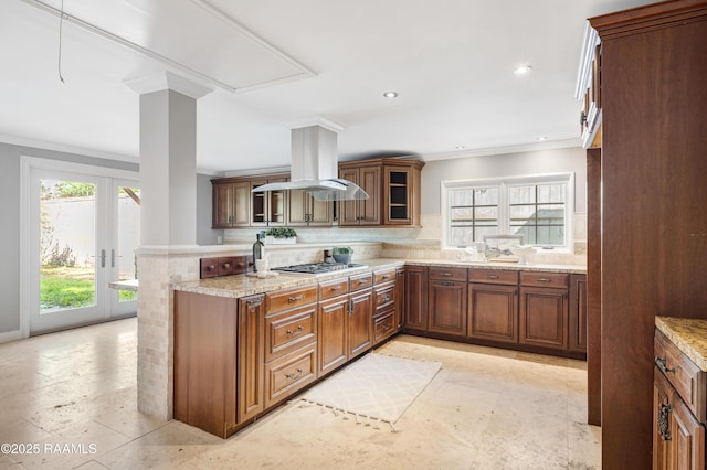 807 Cambridge Dr Res, Unit Res, Lafayette, LA 70503 - kitchen featuring ornamental molding, tasteful backsplash, stainless steel gas stovetop, island range hood, and glass insert cabinets