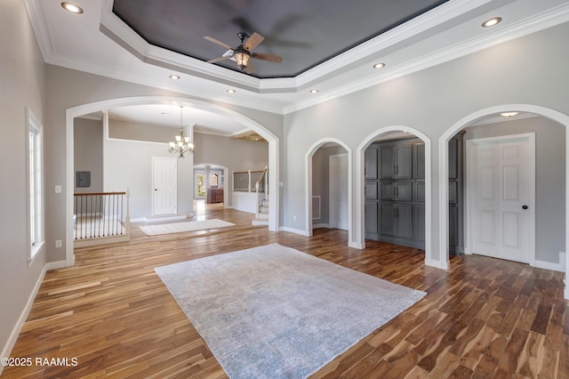 807 Cambridge Dr Res, Unit Res, Lafayette, LA 70503 - unfurnished living room featuring arched walkways, ceiling fan, baseboards, a raised ceiling, and wood finished floors