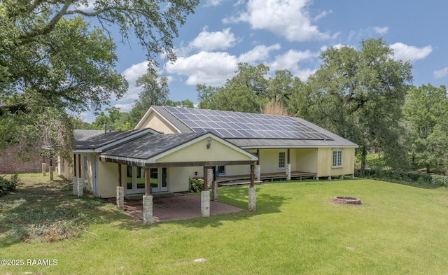 807 Cambridge Dr Res, Unit Res, Lafayette, LA 70503 - view of front of house with solar panels, a front lawn, an outdoor fire pit, french doors, and a patio