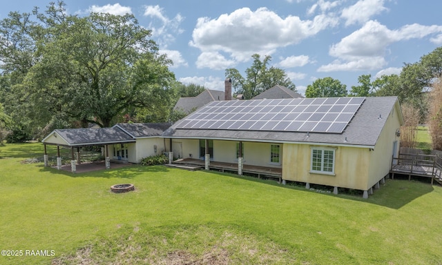 807 Cambridge Dr Res, Unit Res, Lafayette, LA 70503 - back of house featuring a fire pit, a lawn, a shingled roof, and roof mounted solar panels