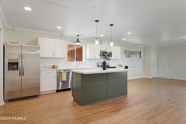 17639 Pelican Rd, Erath, LA 70533 - kitchen with appliances with stainless steel finishes, a center island, white cabinetry, light wood finished floors, and crown molding