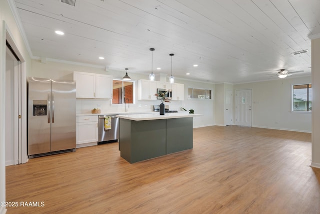 17639 Pelican Rd, Erath, LA 70533 - kitchen featuring stainless steel appliances, white cabinetry, light countertops, a kitchen island, and light wood finished floors