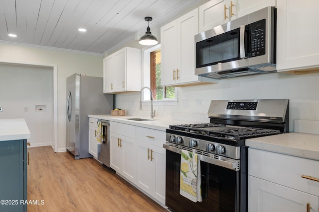 17639 Pelican Rd, Erath, LA 70533 - kitchen featuring stainless steel appliances, a sink, light countertops, crown molding, and light wood-type flooring