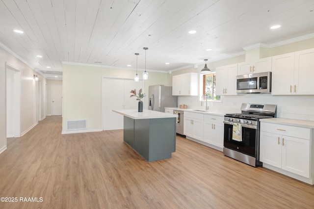 17639 Pelican Rd, Erath, LA 70533 - kitchen featuring appliances with stainless steel finishes, crown molding, a sink, a kitchen island, and light wood-style floors