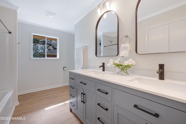 17639 Pelican Rd, Erath, LA 70533 - bathroom featuring ornamental molding, double vanity, wood finished floors, baseboards, and shower / washtub combination