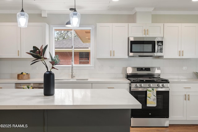 17639 Pelican Rd, Erath, LA 70533 - kitchen featuring stainless steel appliances, white cabinets, crown molding, tasteful backsplash, and decorative light fixtures
