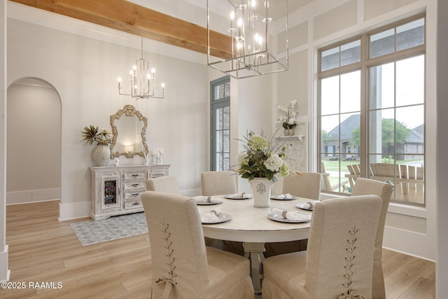 137 Grandview Terrace Dr, Youngsville, LA 70592 - dining area with a chandelier, arched walkways, light wood finished floors, a high ceiling, and baseboards