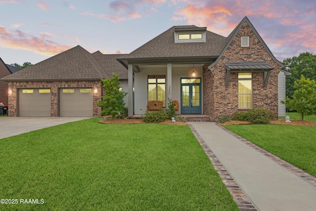 137 Grandview Terrace Dr, Youngsville, LA 70592 - view of front of house with french doors, a shingled roof, brick siding, a yard, and concrete driveway