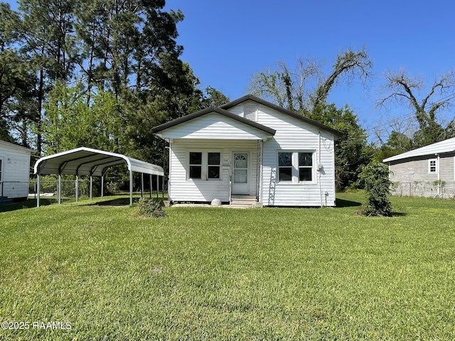 617 E Madison St, Opelousas, LA 70570 - back of property featuring entry steps, a carport, and a lawn