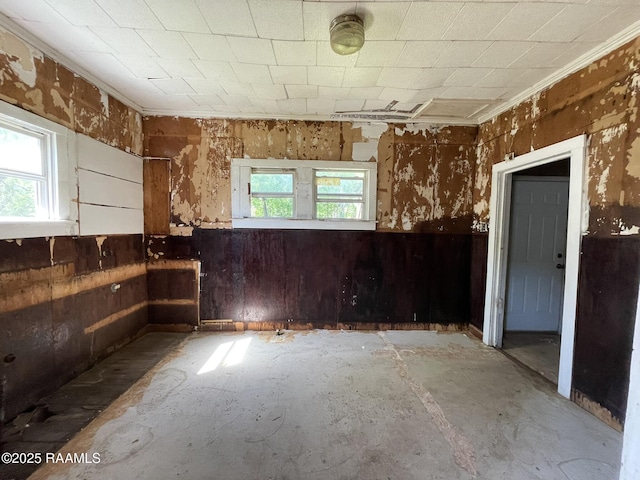 617 E Madison St, Opelousas, LA 70570 - empty room featuring plenty of natural light, wooden walls, a wainscoted wall, and crown molding